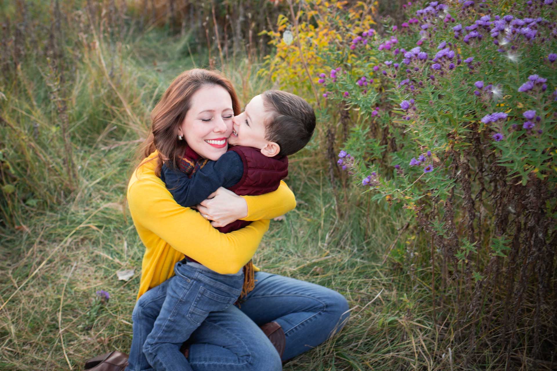 mom in yellow sweater hugging toddler son in field big island Hawaii family photographer