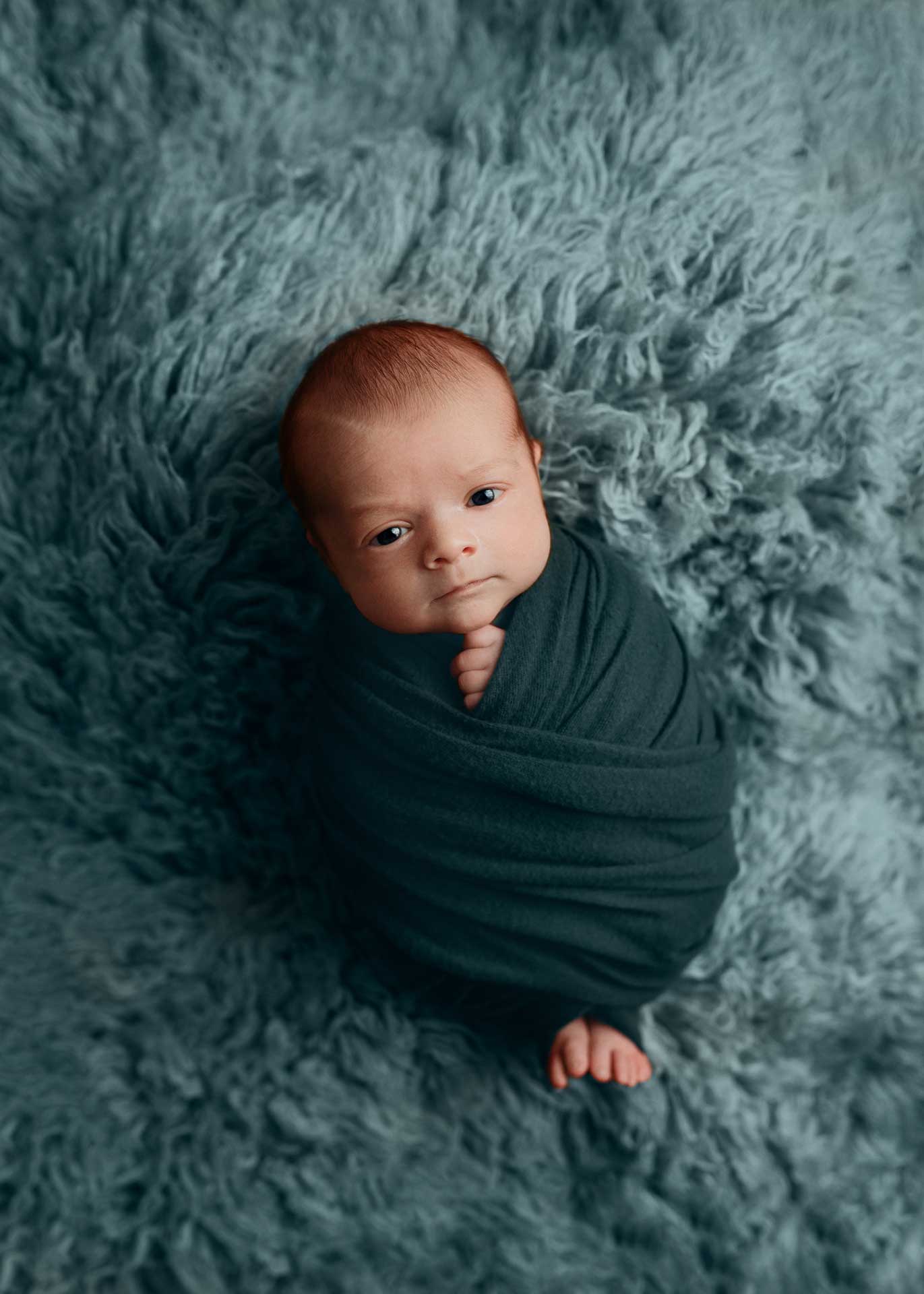 baby boy in toes out wrap in teal on matching flokati kona Hawaii big island newborn photographer