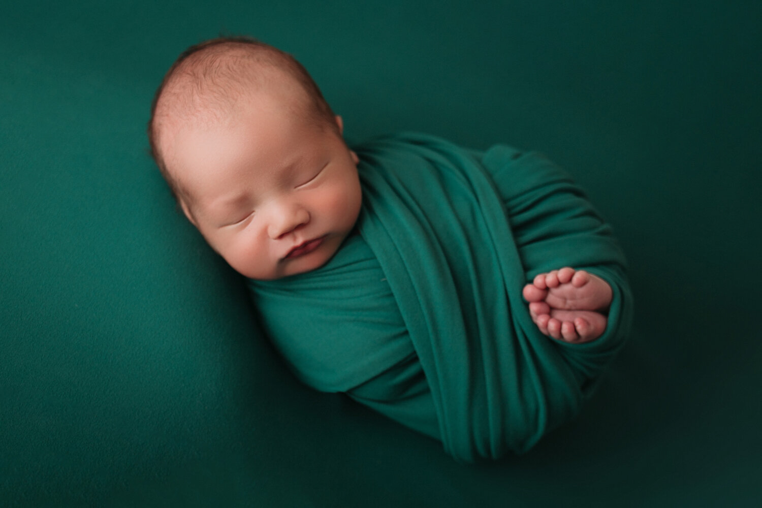 newborn baby on emerald green in newborn photographer minneapolis minnesota