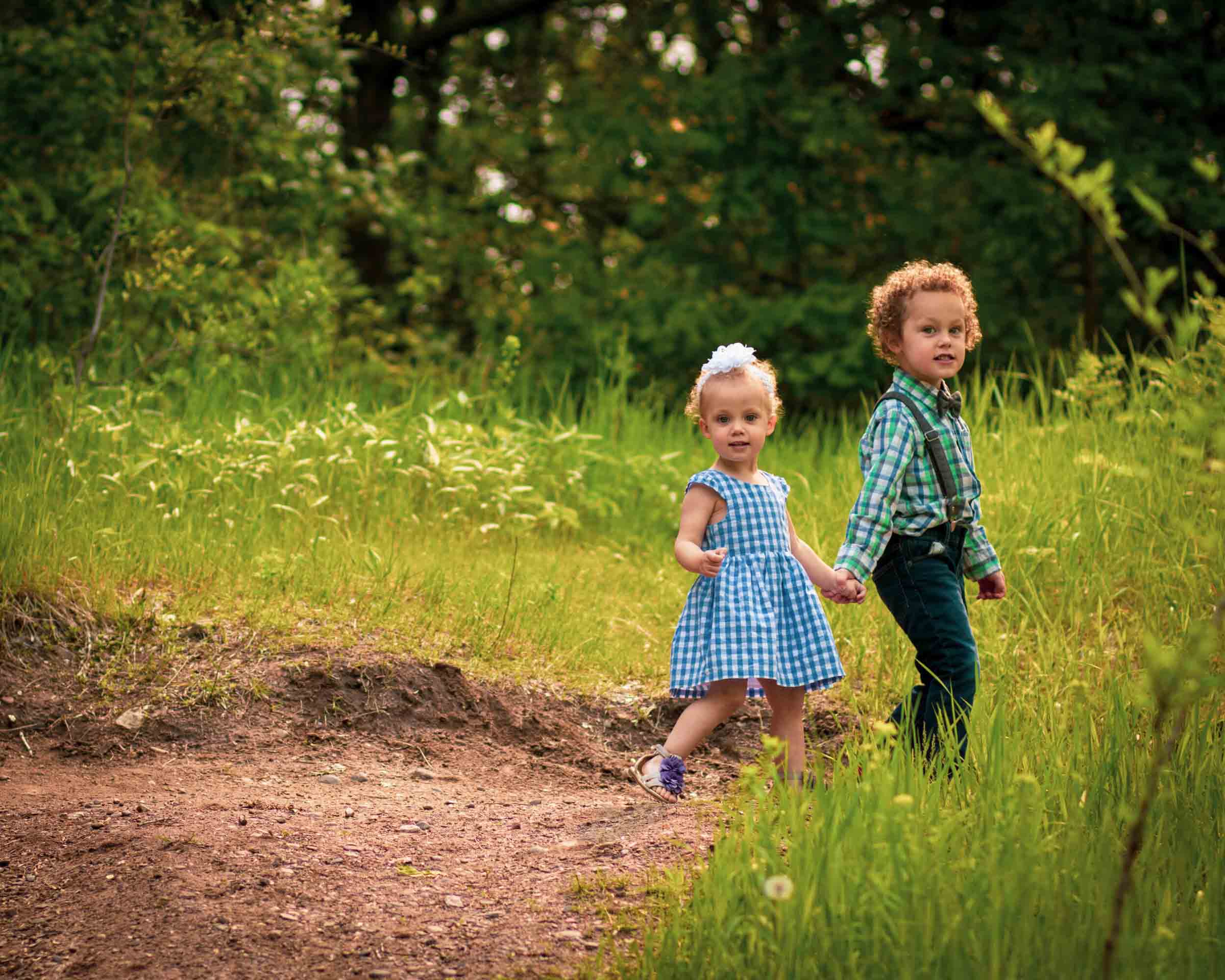 brother and sister walking hand in hand in field minneapolis minnesota family photography