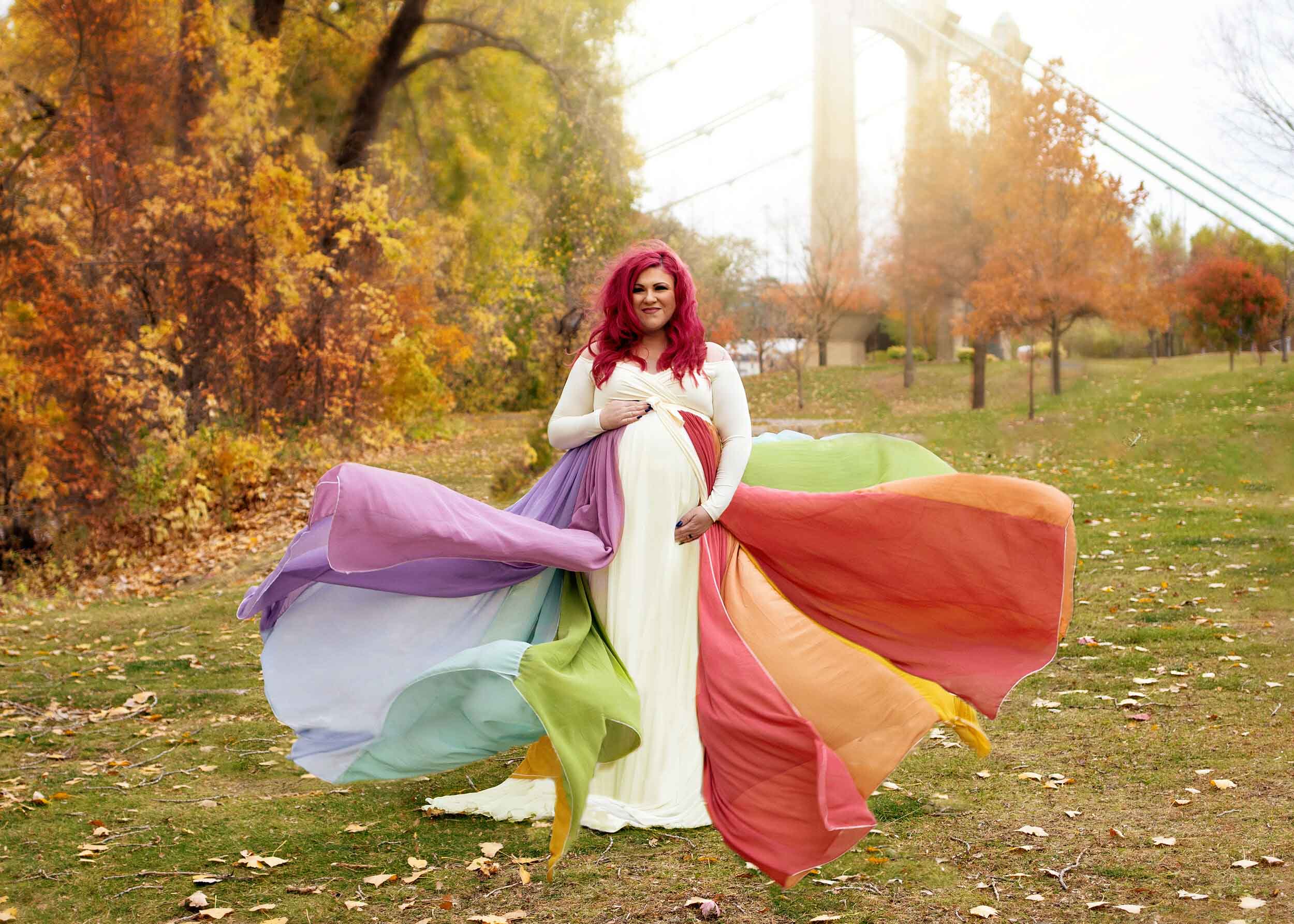 plus size mom in rainbow flowy gown in fall foliage minneapolis maternity photography