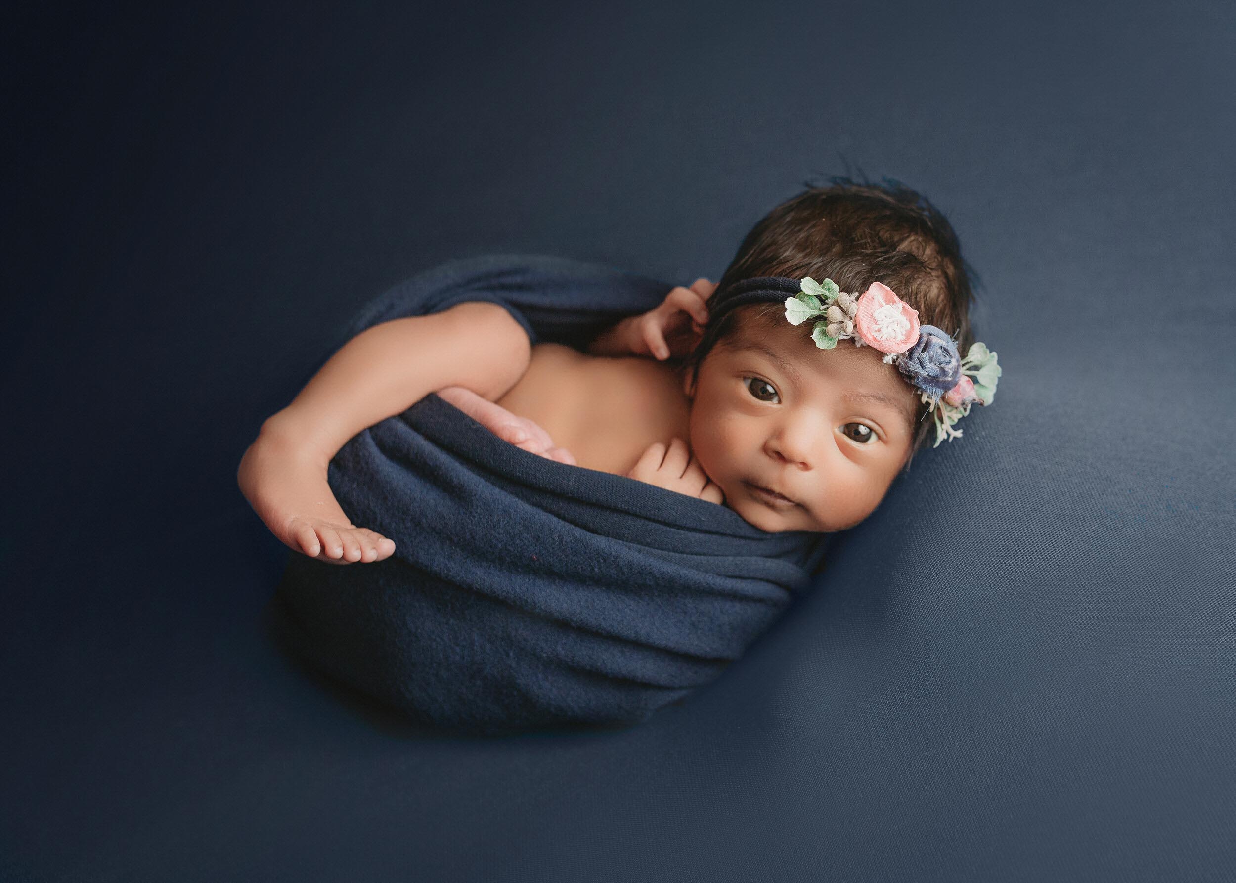 newborn girl in egg wrap and navy for newborn photographer session in minneapolis mn