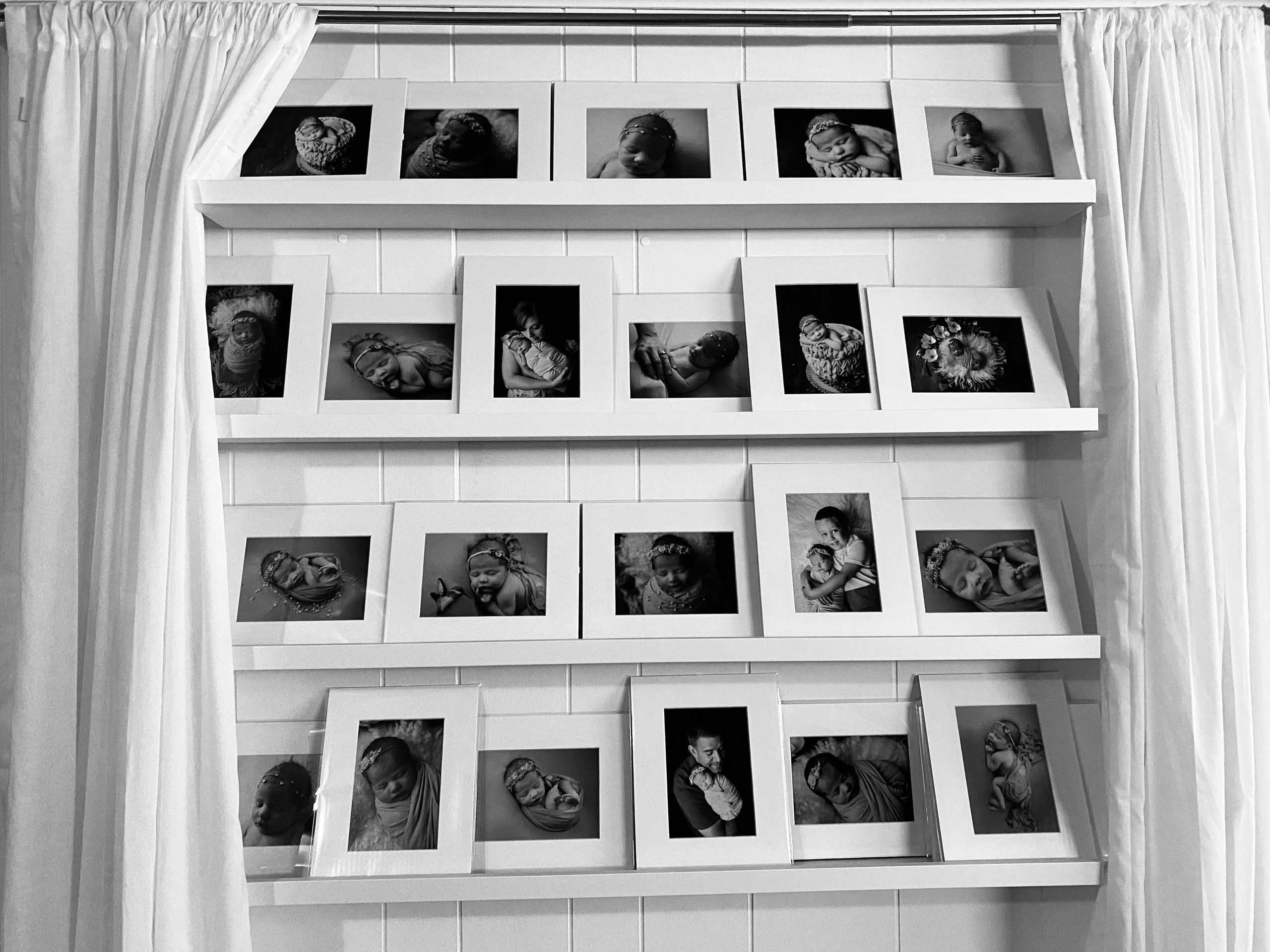 reveal wall set up for newborn session matted images on shelves behind curtains