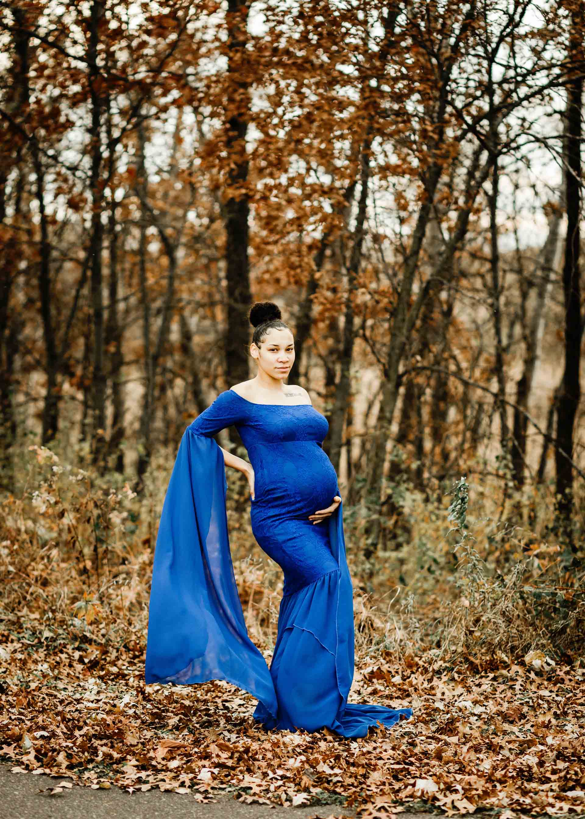 maternity in blue dress with bell sleeves in fall forest maternity photography session minneapolis
