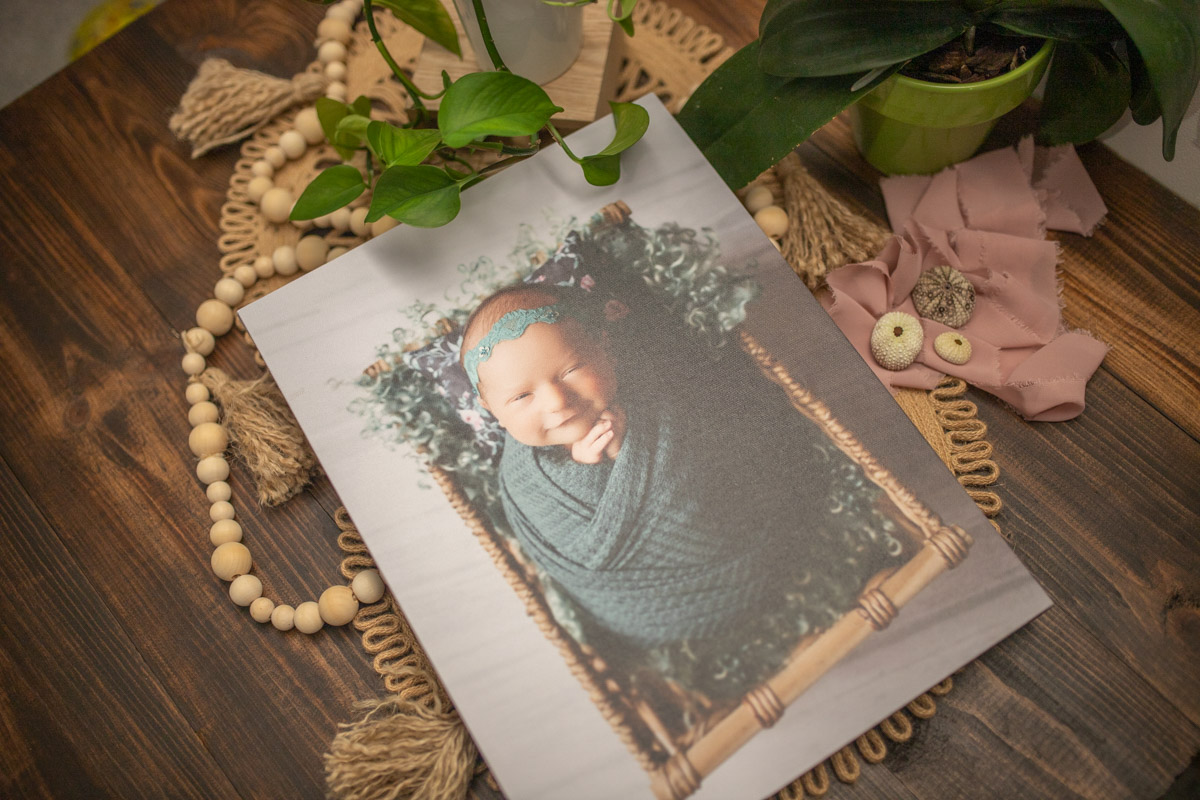 canvas of newborn girl in basket with teal and pink pillow newborn photographer kona Hawaii big island
